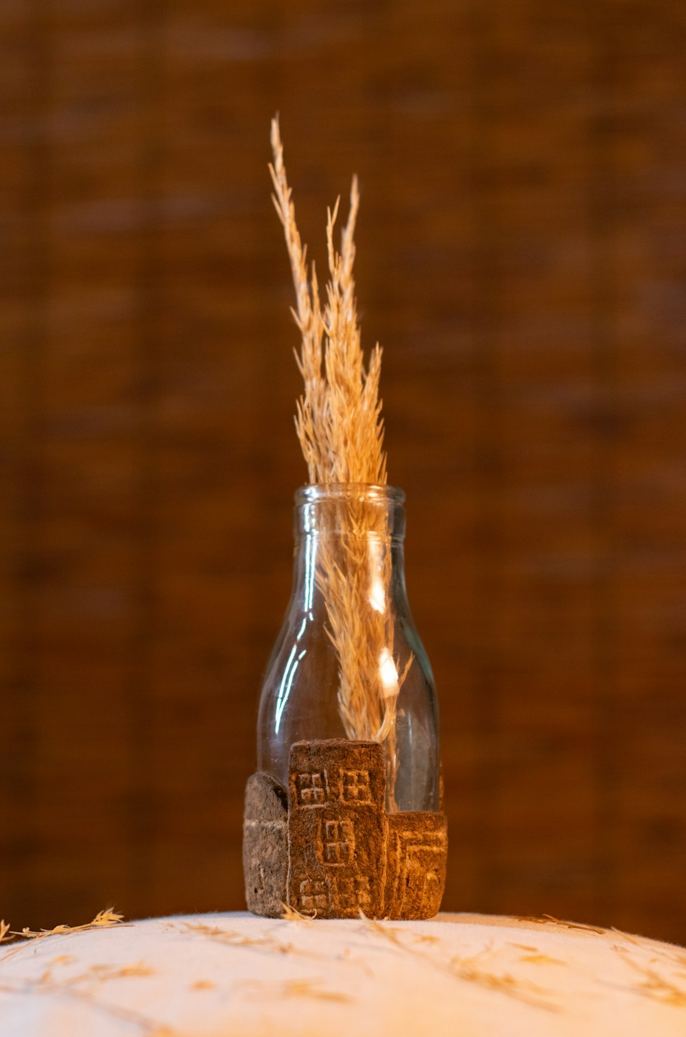 a glass jar with some dried plants in it