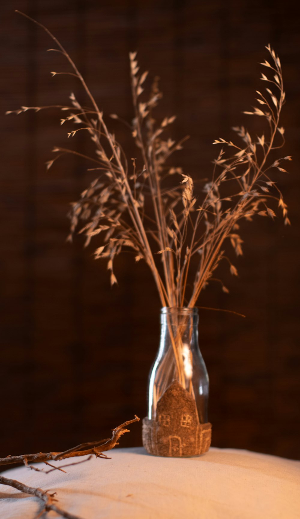 a vase filled with dried plants sitting on top of a table
