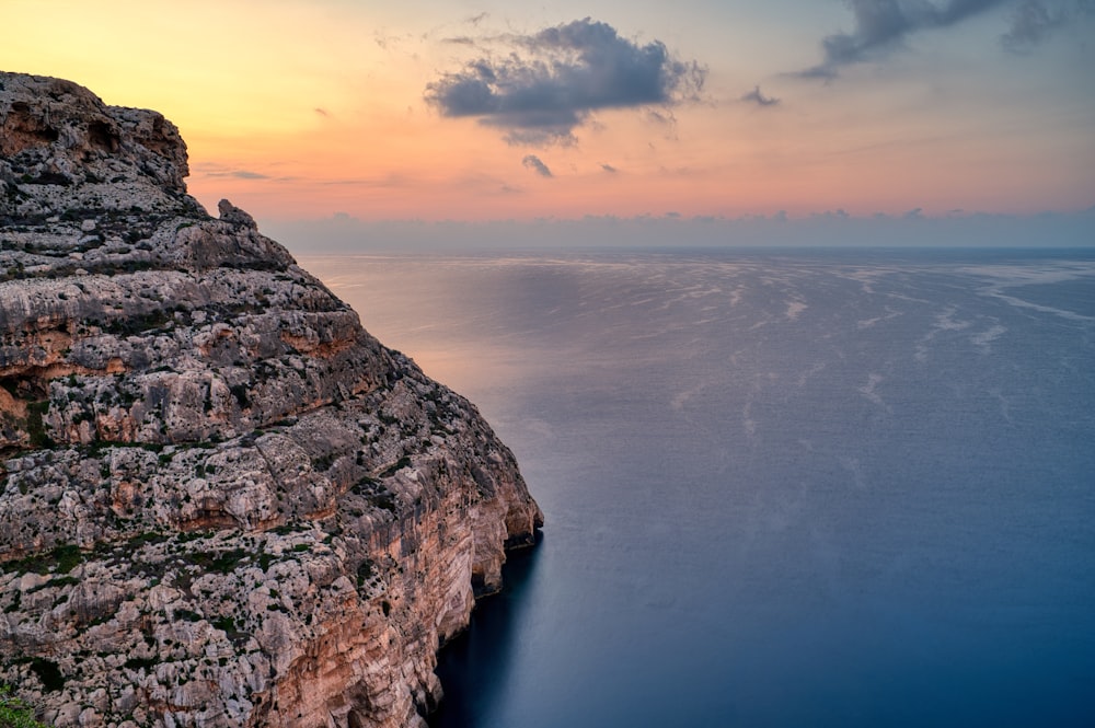 a large body of water next to a rocky cliff