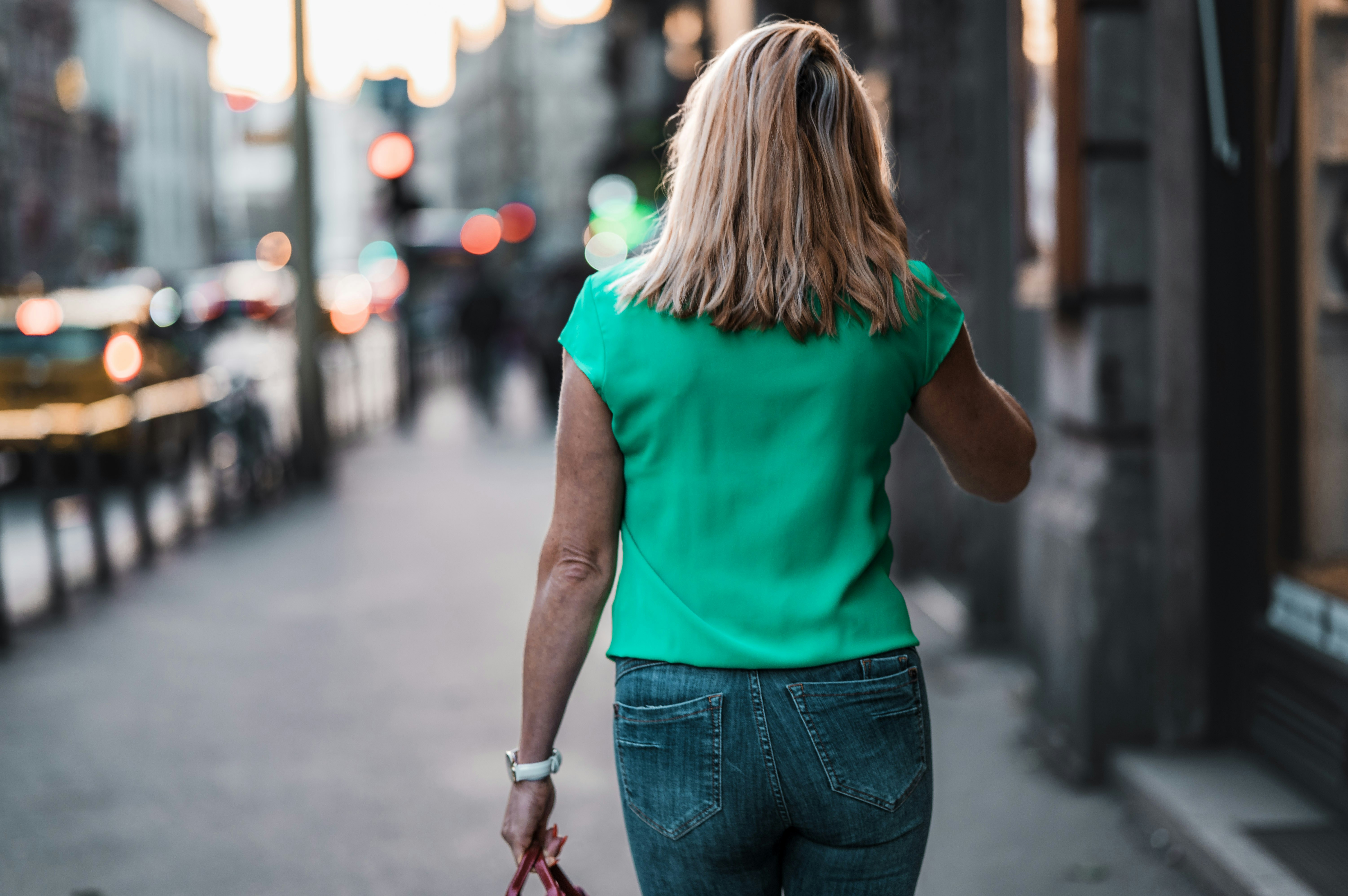 a woman walking down a street talking on a cell phone