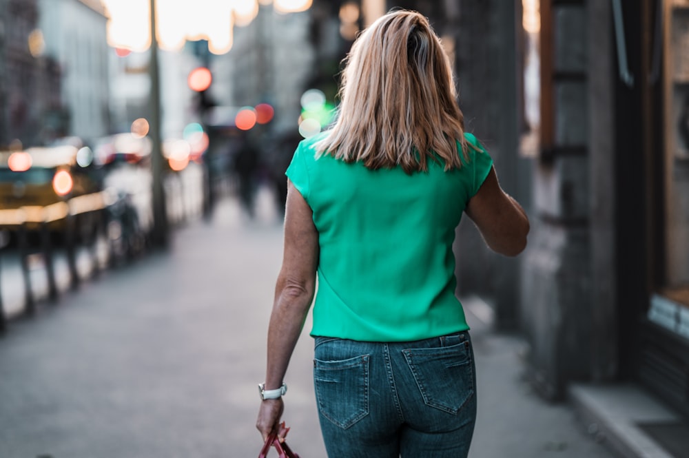 a woman walking down a street talking on a cell phone