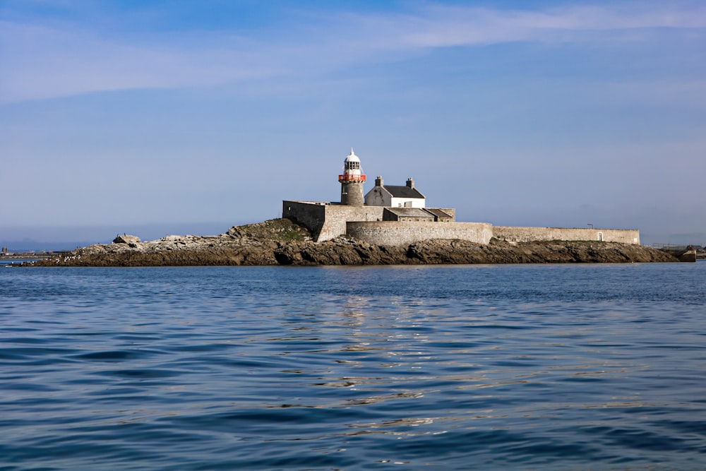 a lighthouse on a small island in the middle of the ocean