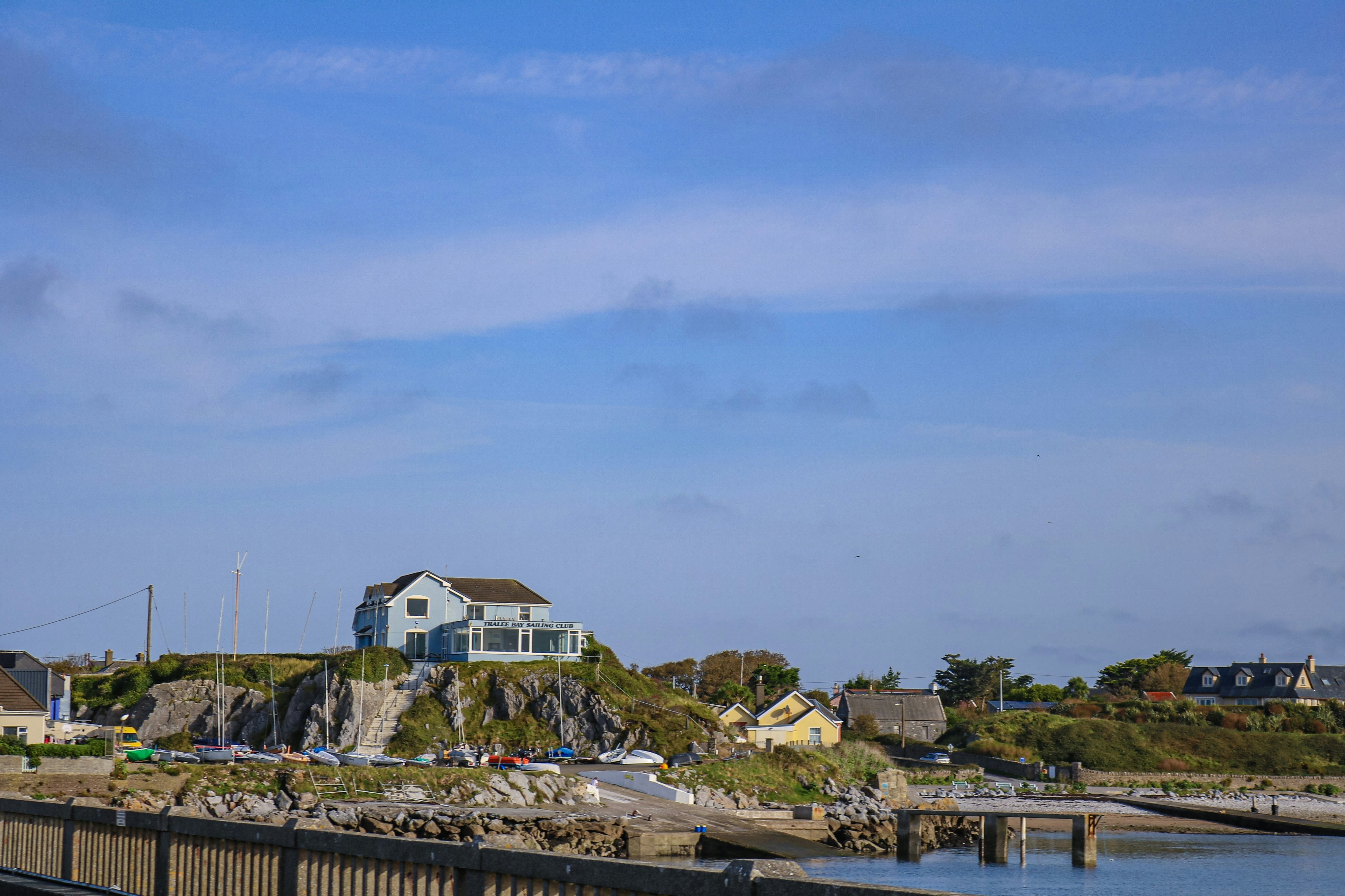 a house sitting on top of a hill next to a body of water