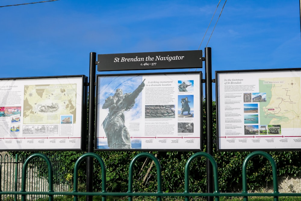 a couple of signs that are next to a fence