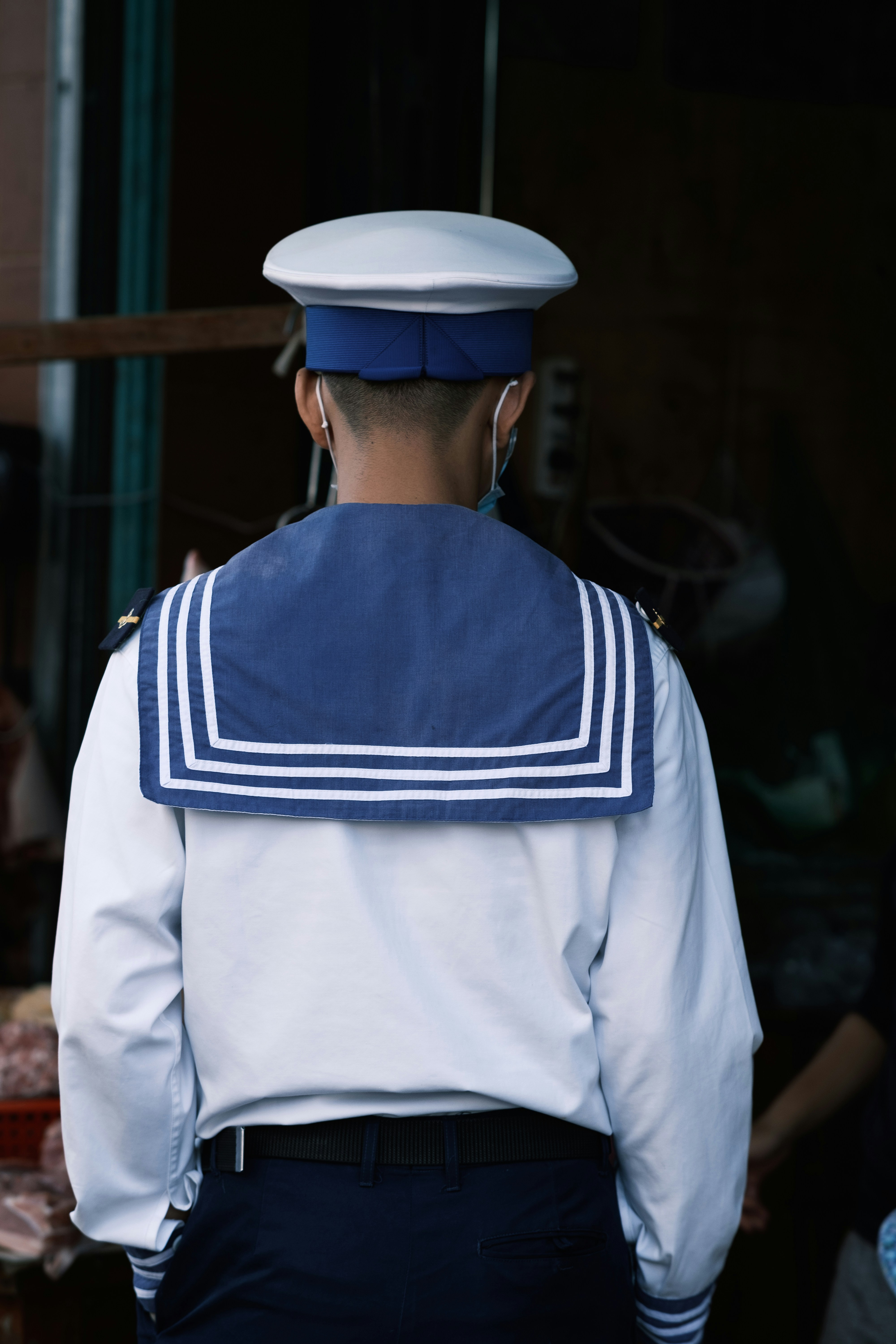 a man in a sailor's uniform standing in front of a building