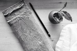 A flat lay of Bloom Room lesson plans, pens, and a small plant on a wooden table.