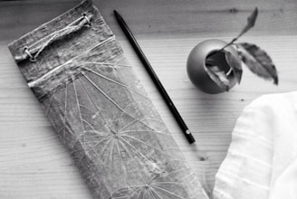 A flat lay of Bloom Room lesson plans, pens, and a small plant on a wooden table.