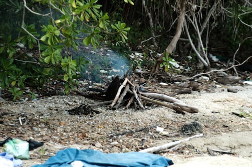 Abandoned campsite with flickering lanterns and scattered gear.