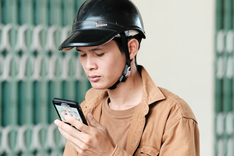 Contractor in a hard hat checking his phone on a job site