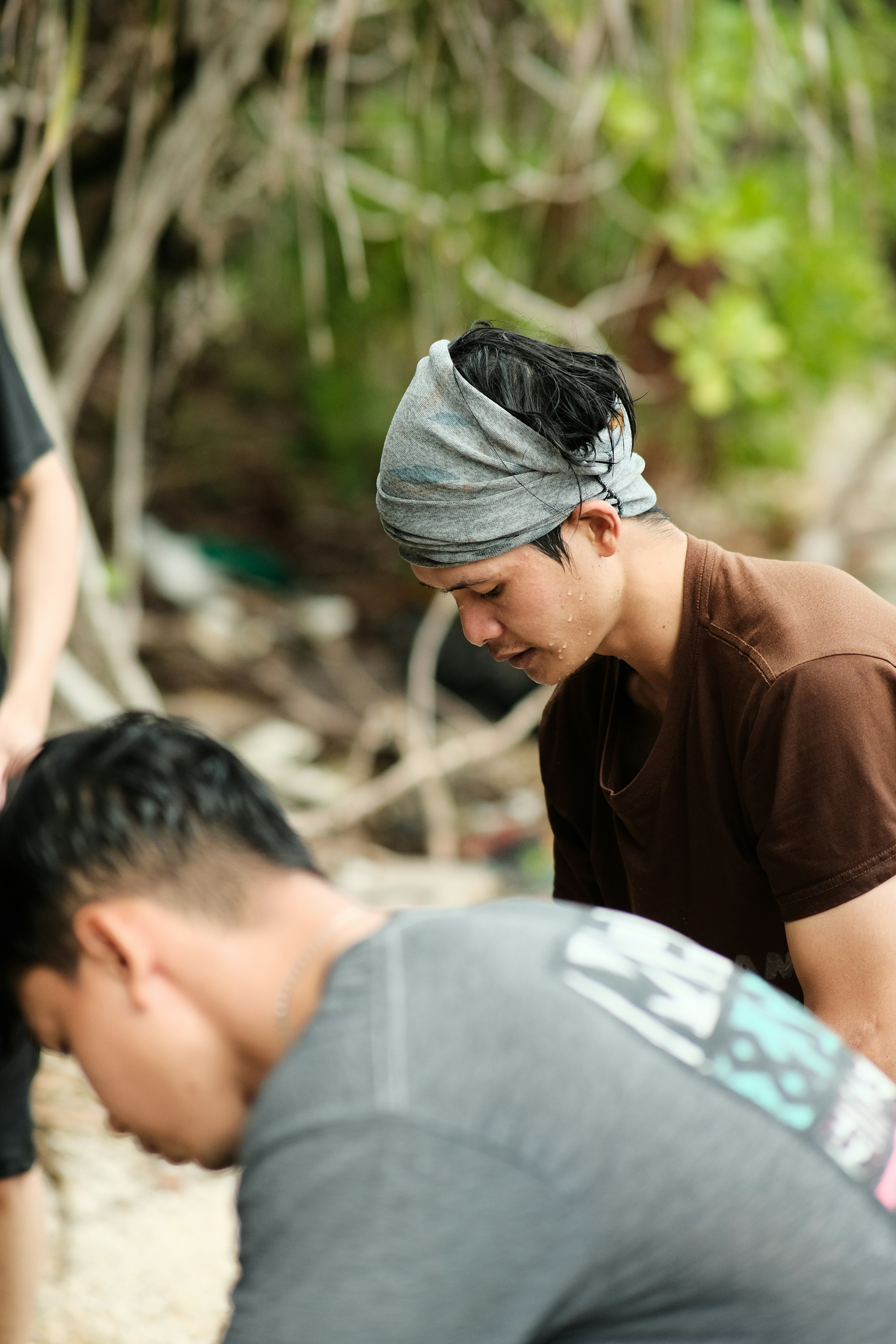 Seorang pria dengan bandana di kepalanya melihat ke bawah