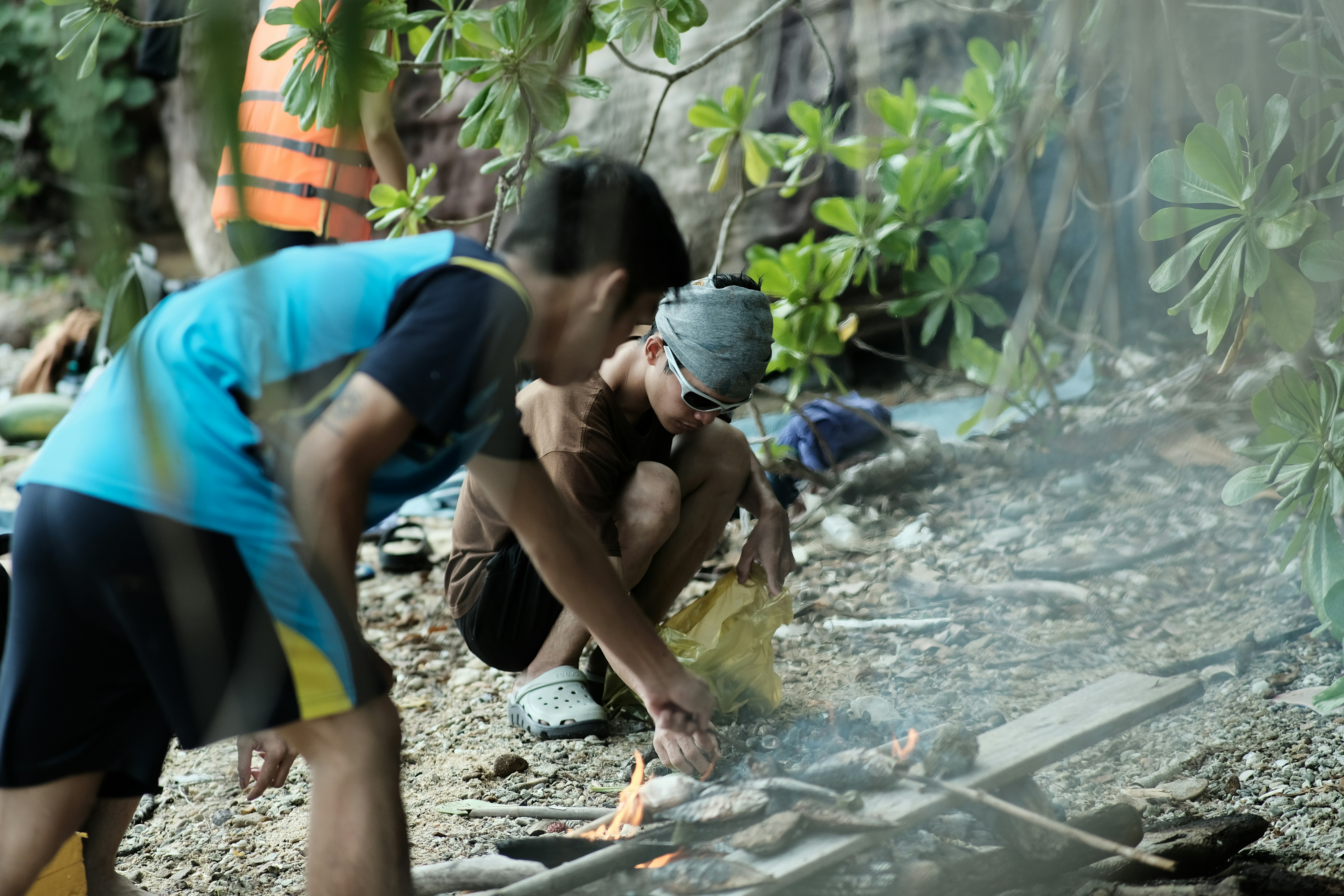a group of people sitting around a fire pit (Photo by Thi Nguyen Duc on Unsplash)