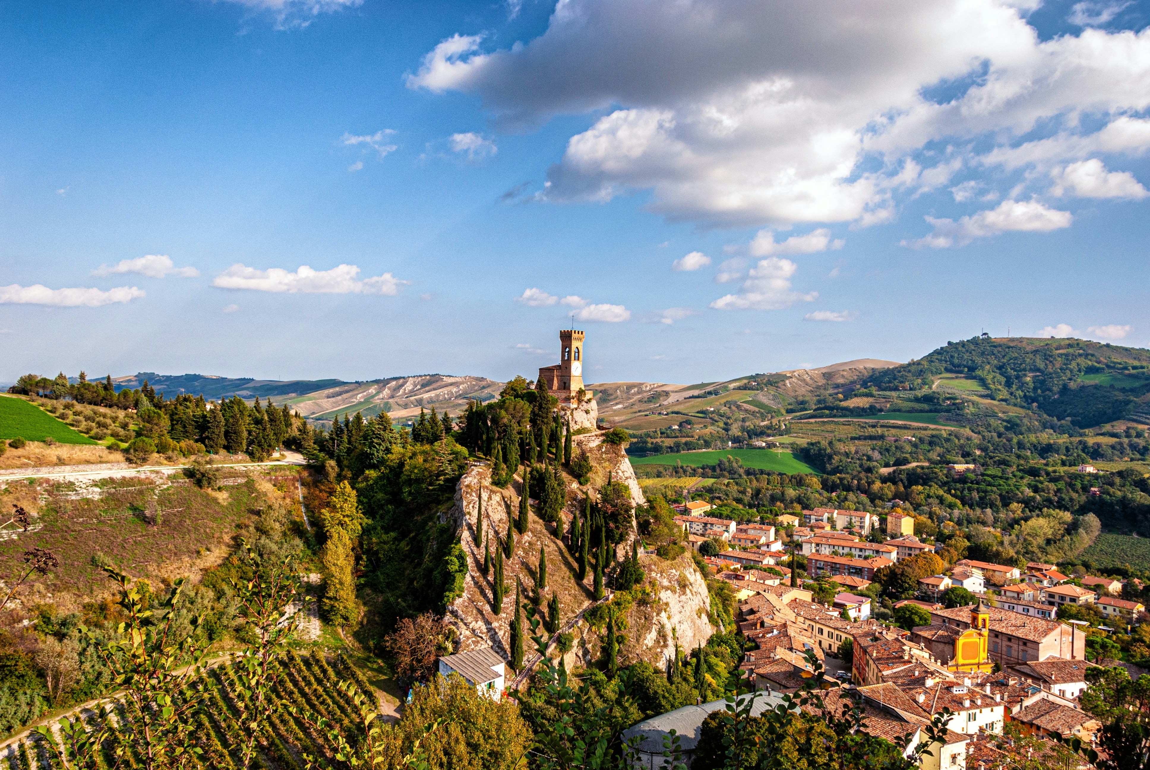 a scenic view of a small town on a hill, Torre dell’Orologio (1290-1850), Brisighella Tuscany