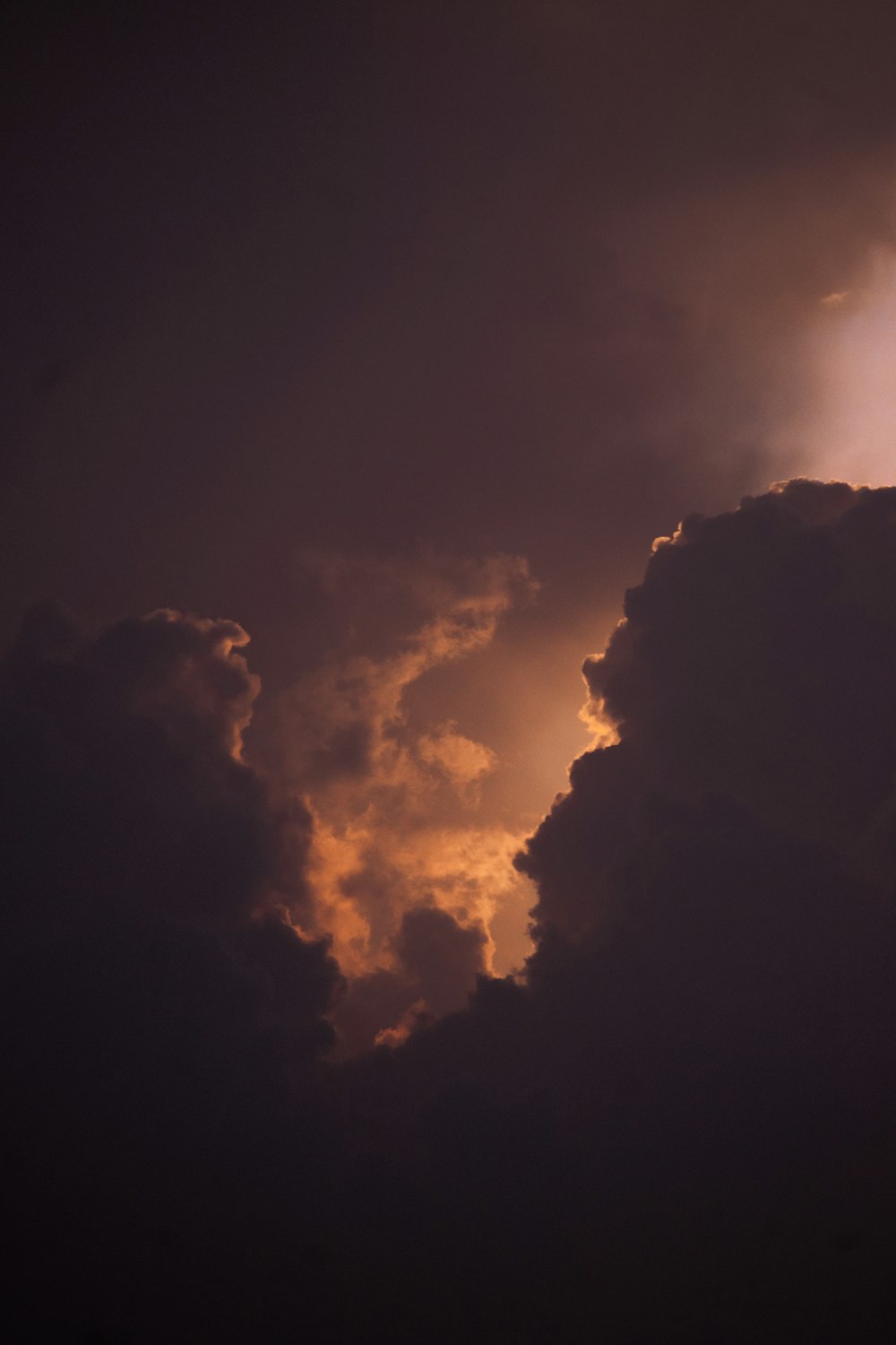 a plane flying through a cloudy sky at night