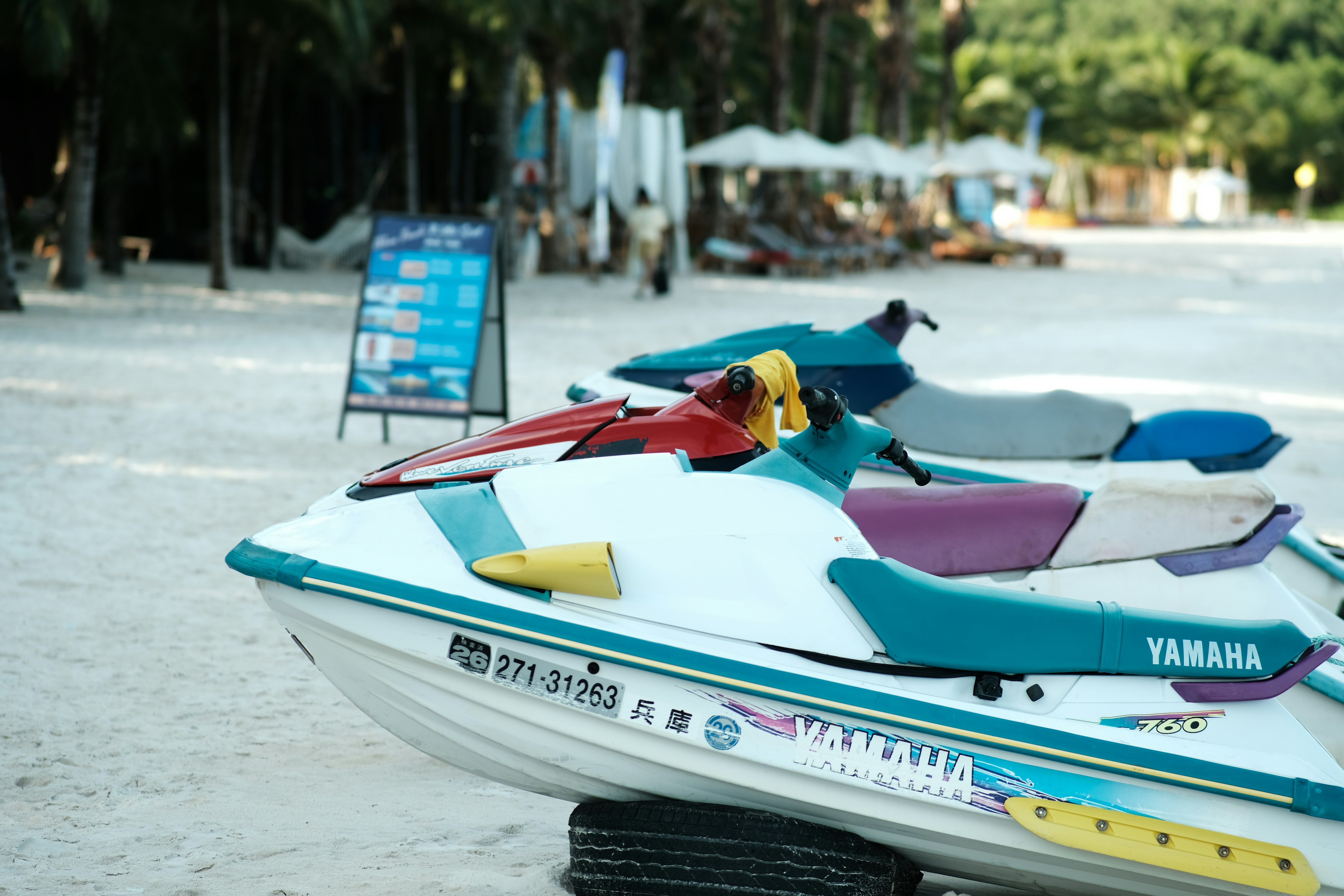 a row of boats sitting on top of a sandy beach