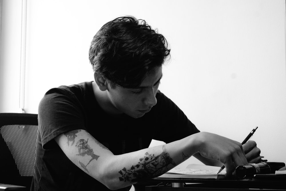 a man sitting at a desk writing on a piece of paper