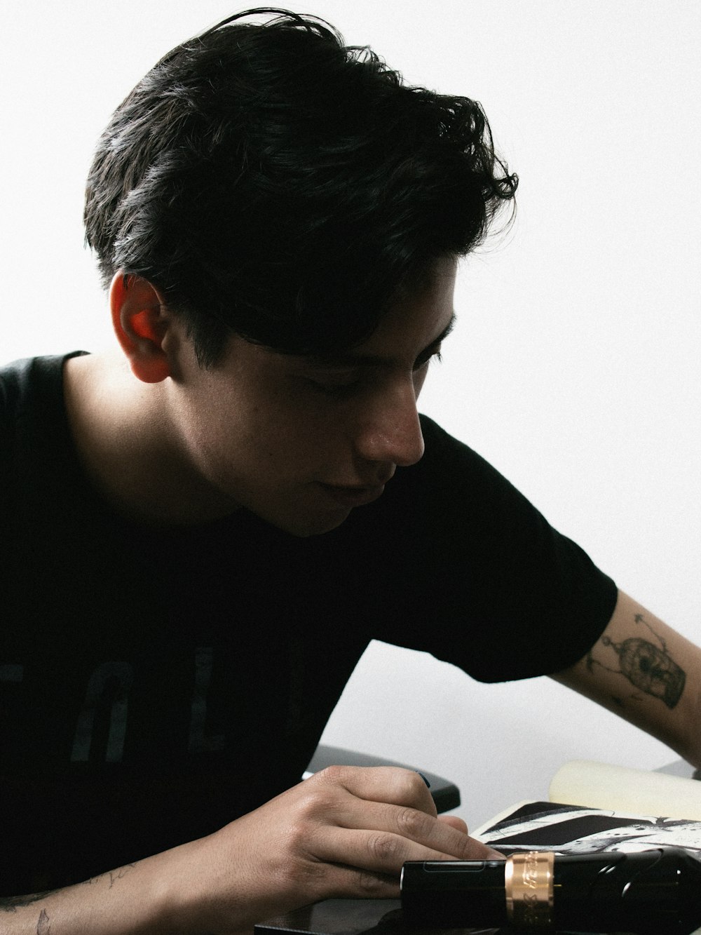 a man sitting at a table writing on a piece of paper