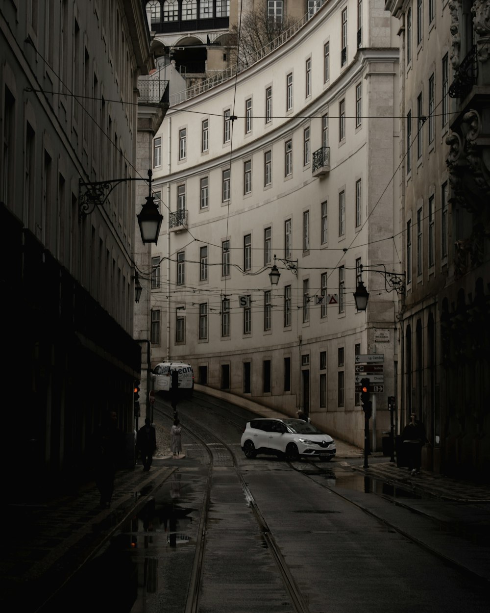 a car is driving down a narrow city street