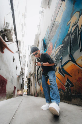 Dynamic shot of a Black man mid-motion, wearing streetwear with a vivid palette, surrounded by urban murals.