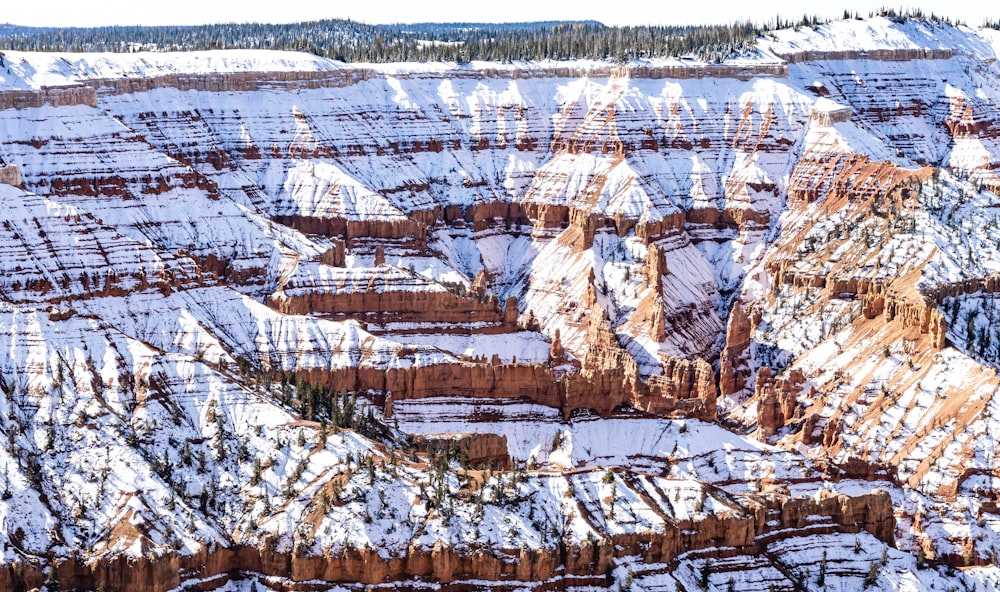 a snow covered landscape with a mountain in the background