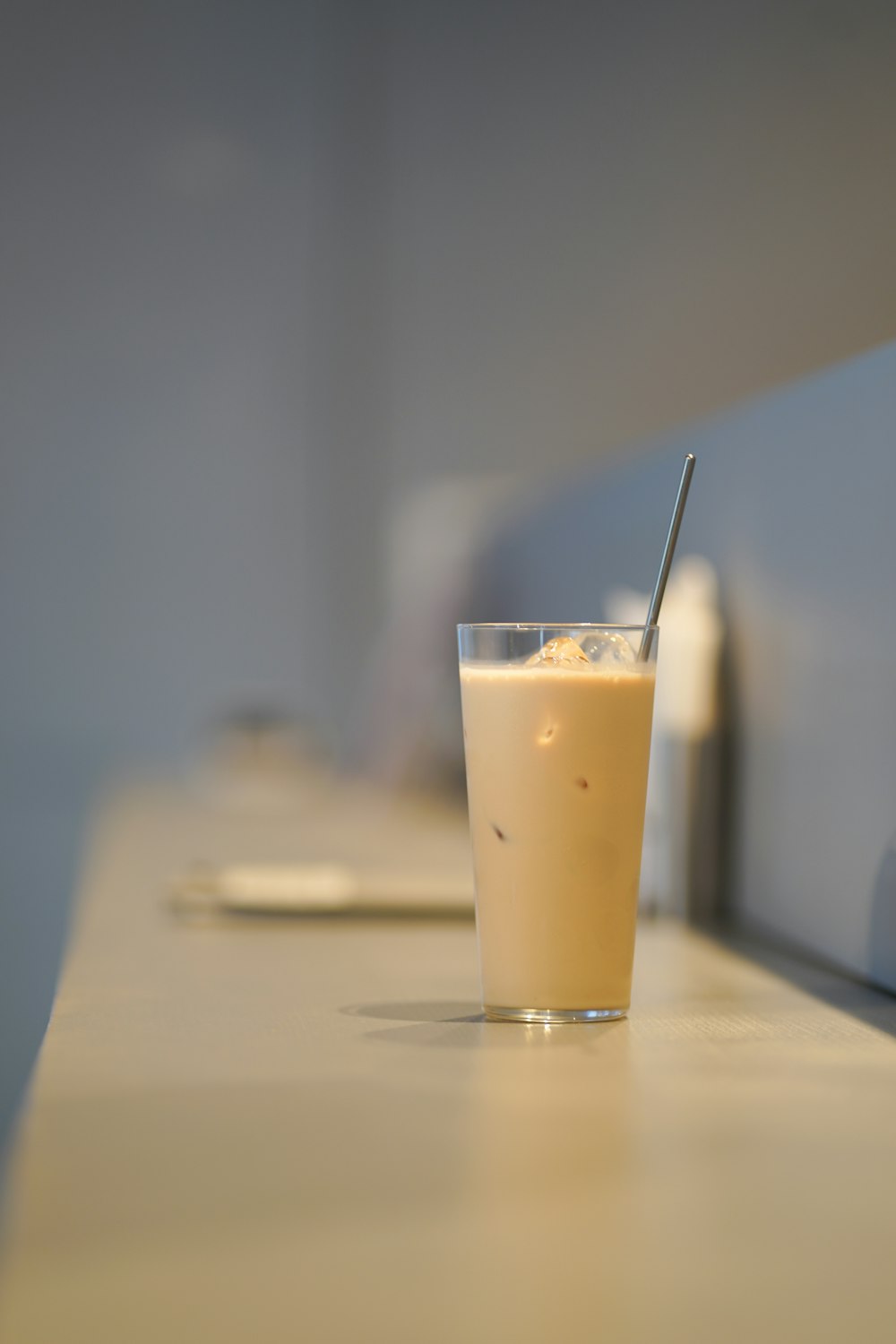 a glass with a straw in it sitting on a counter