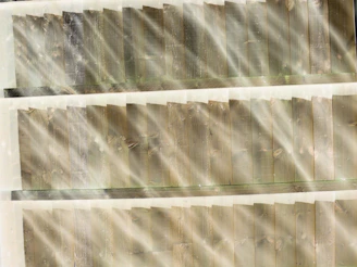 Sunlight filtering through timber beams creating warm shadows on wooden floorboards.