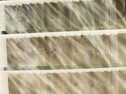 Sunlight filtering through timber beams creating warm shadows on wooden floorboards.