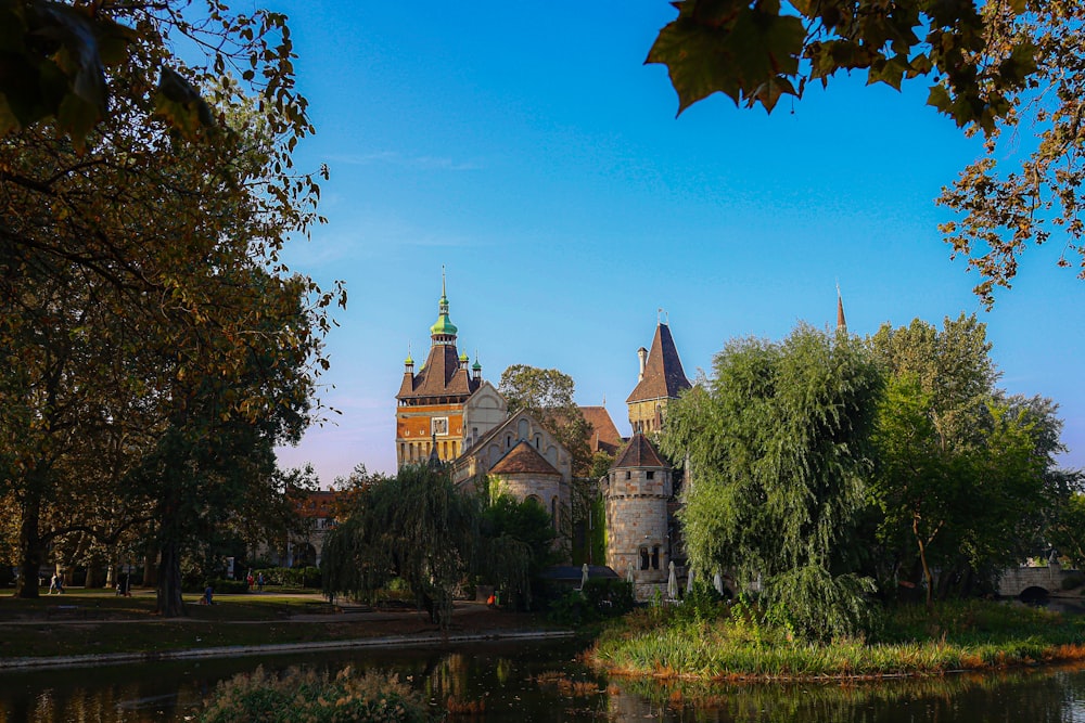 a large castle with towers and a lake in front of it