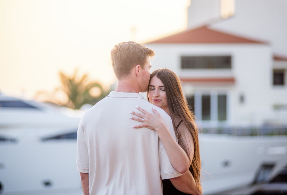 a man and a woman embracing in front of a boat