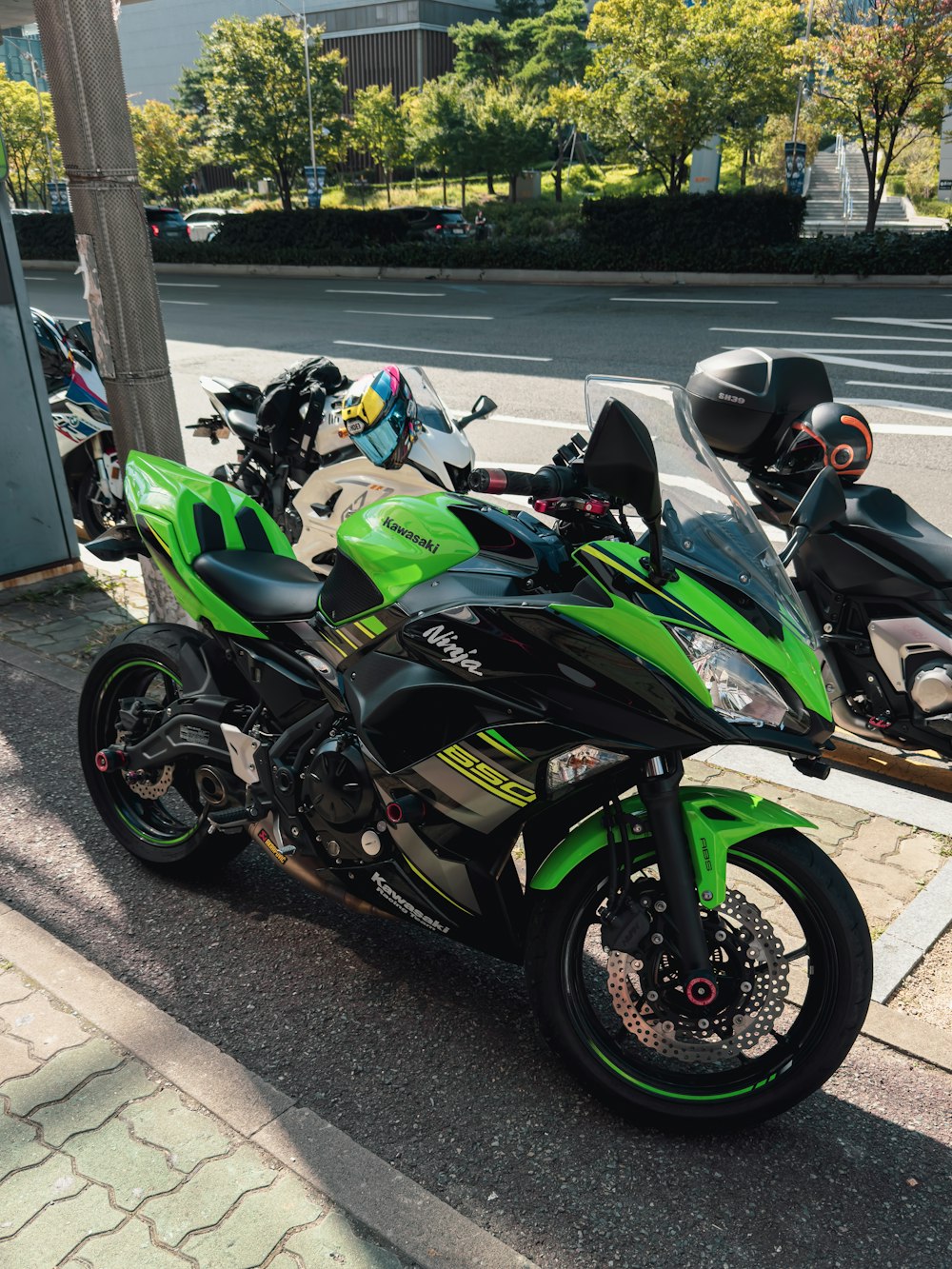 a green and black motorcycle parked on the side of the road
