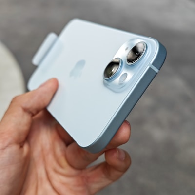 Hands holding a cutting-edge gadget with a futuristic design under soft blue lighting.