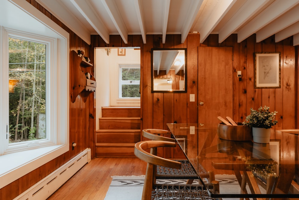 a dining room with wood paneling and a glass table