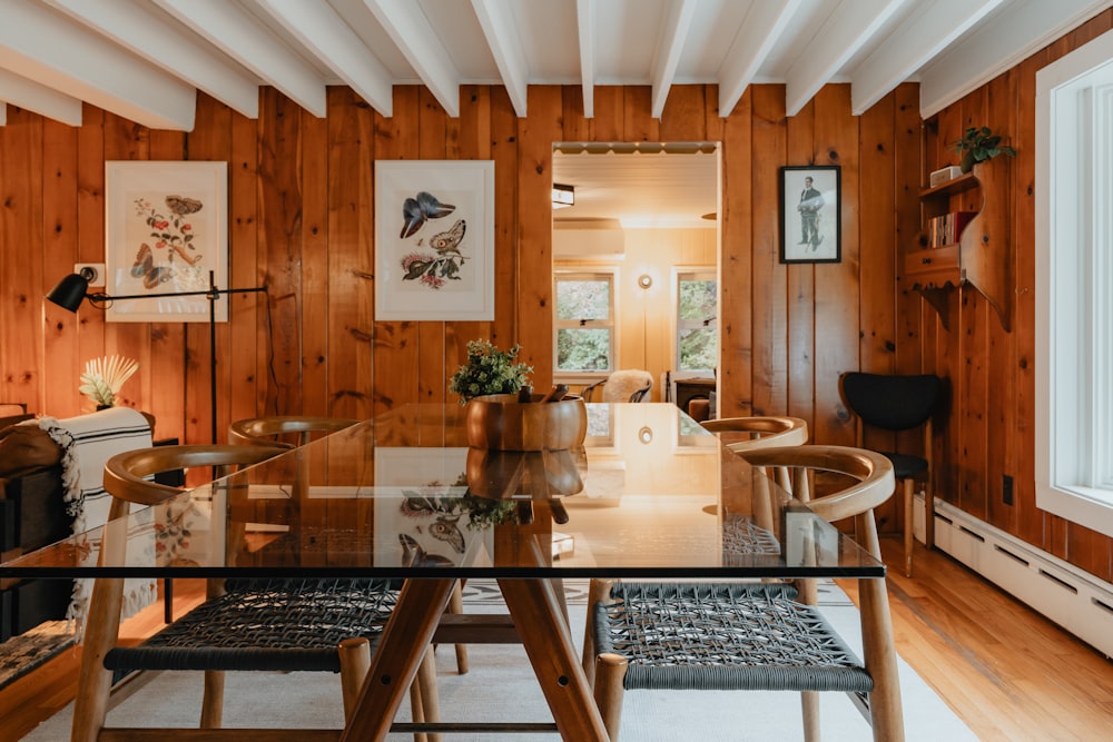 a dining room with wood paneling and a glass table