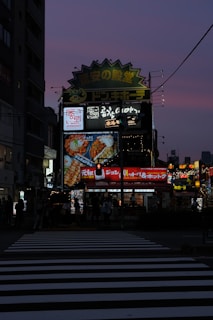 A bustling street in Japan at dusk, with neon signs glowing softly in purple hues.