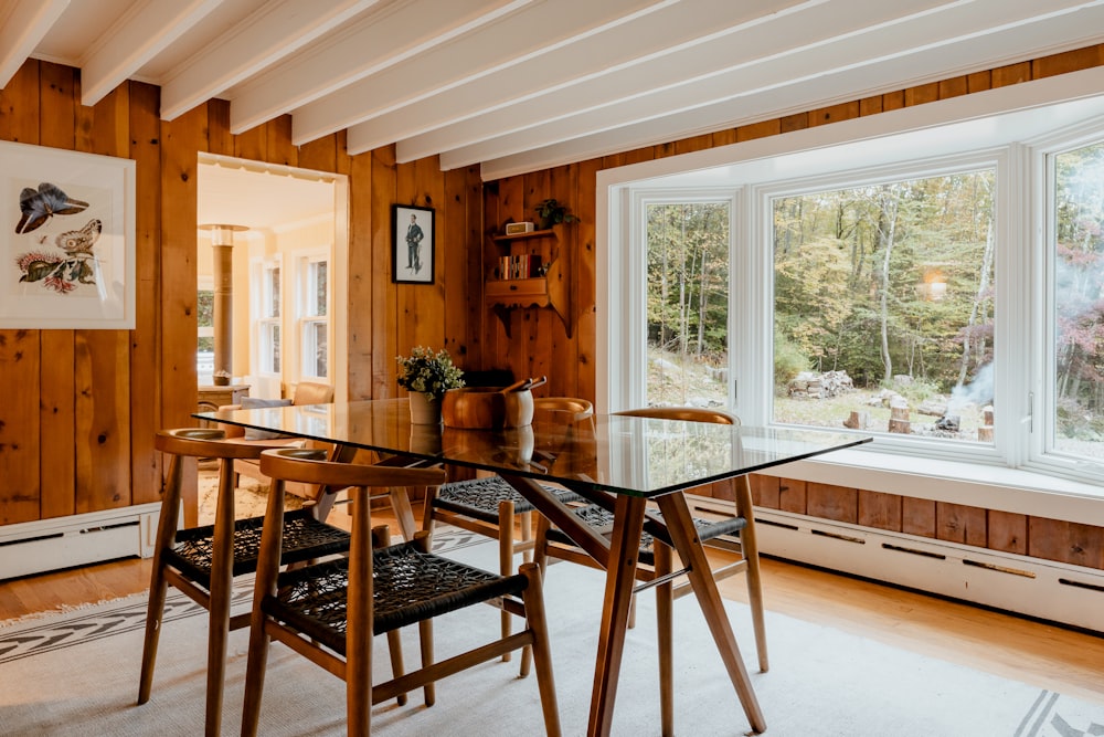 a dining room table and chairs in front of a window