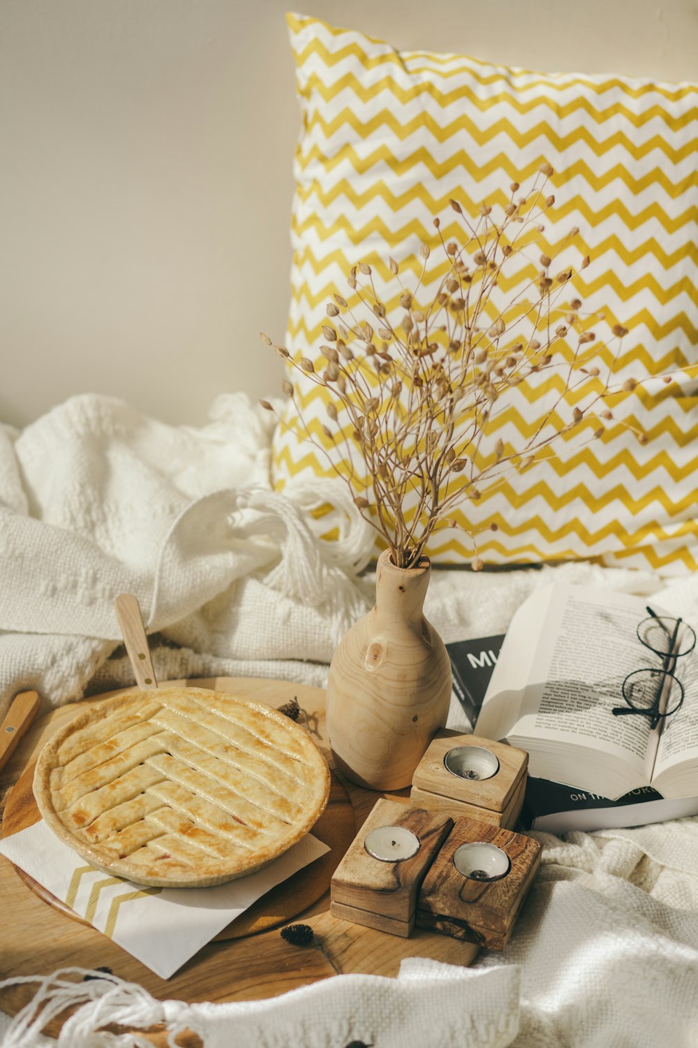 a table topped with a pie next to a pillow