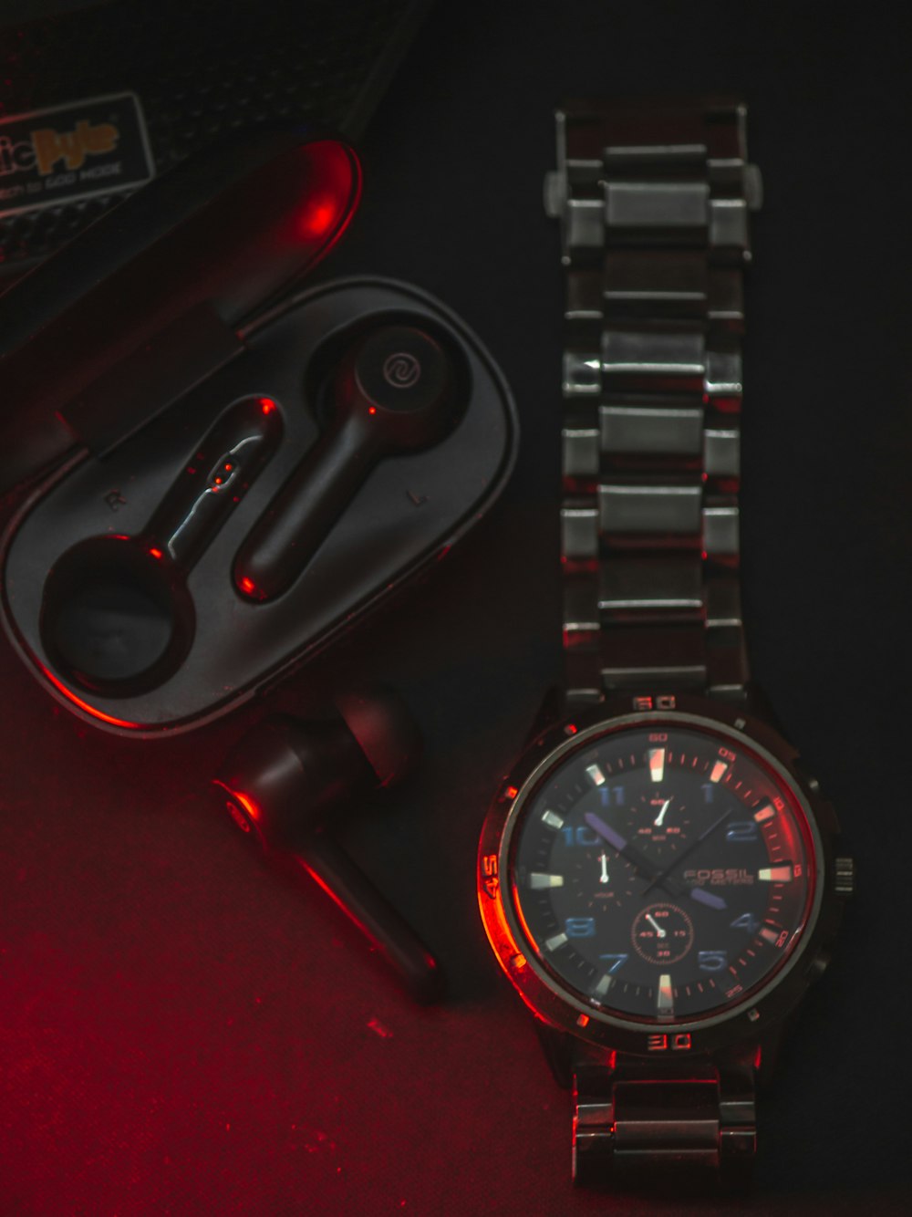 a watch and a pair of ear buds on a table