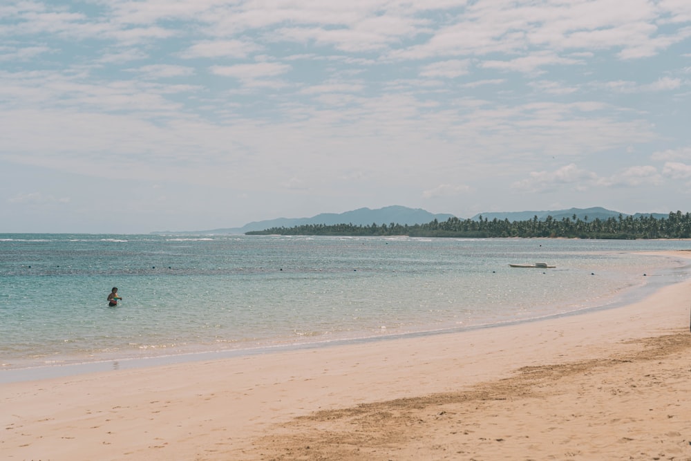 a person standing on a beach next to the ocean