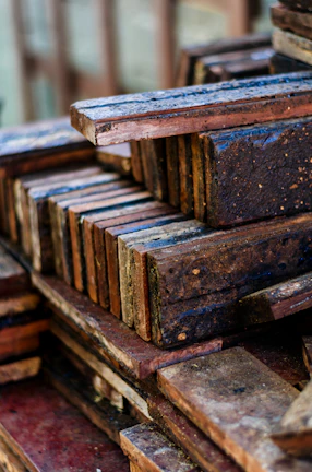 Stacks of quality wooden planks with a navy blue and yellow branded sign nearby.
