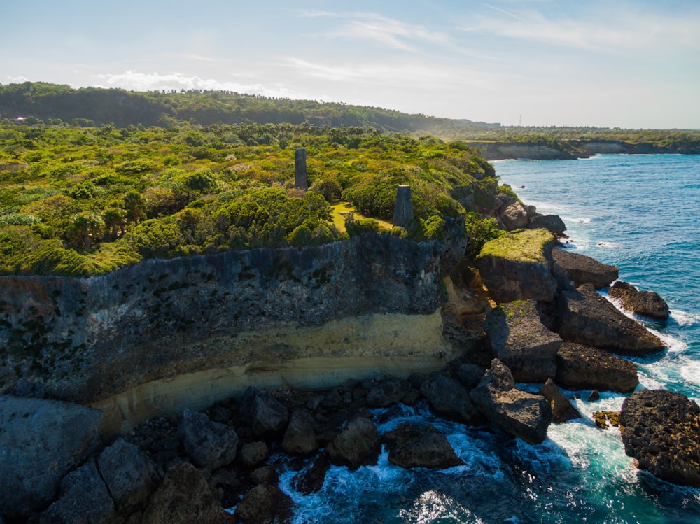 a large body of water next to a lush green hillside