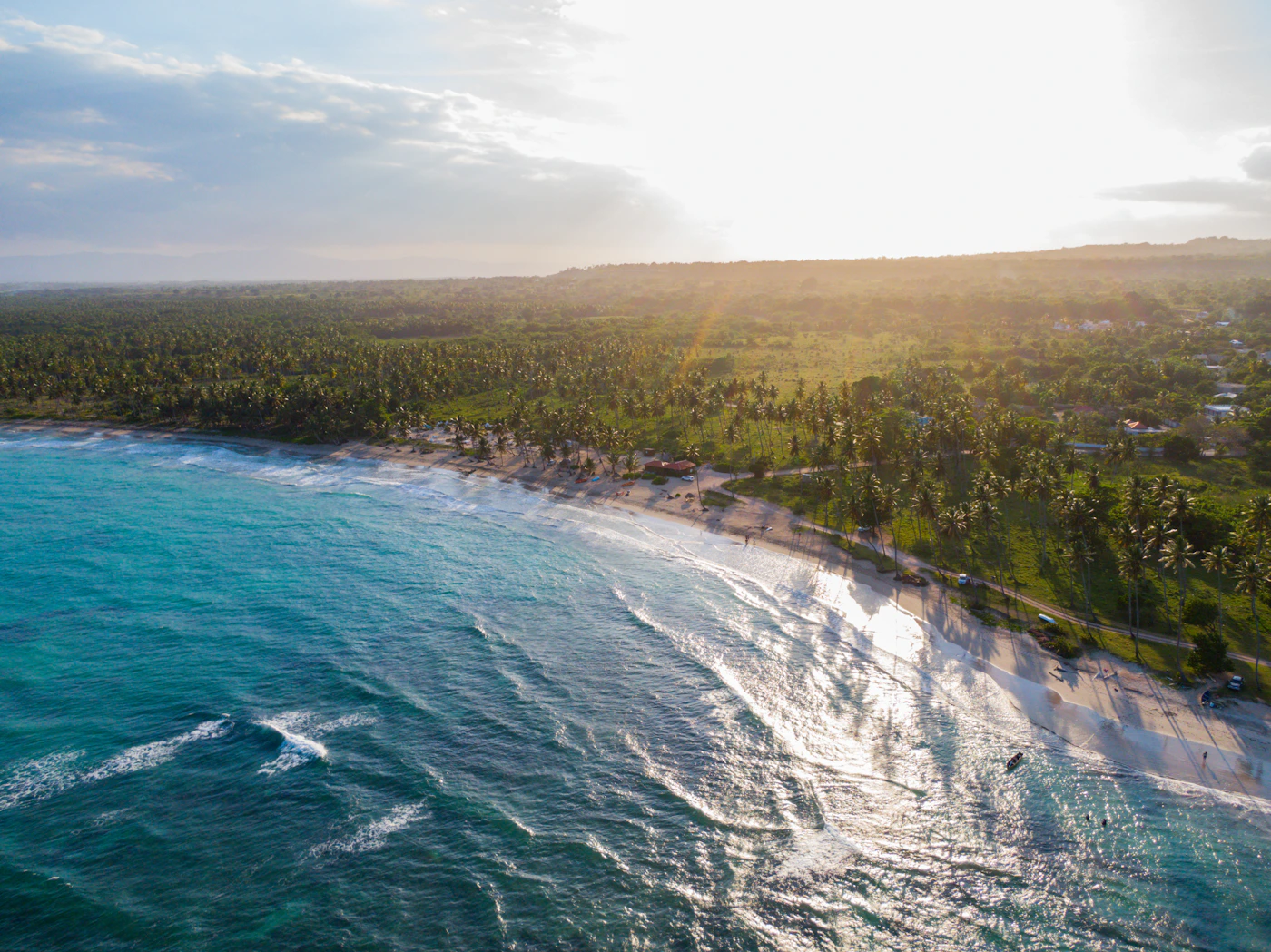 Aerial view of a beautiful turquoise Caribbean beach in the Dominican Republic with the white sand and clear shallow water and boats visible in the deeper water offshore
