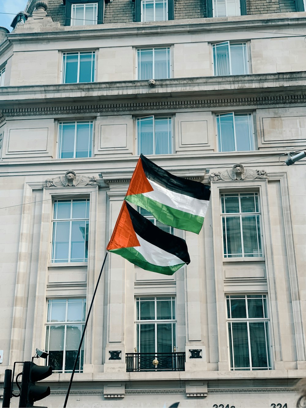 a flag flying in front of a tall building