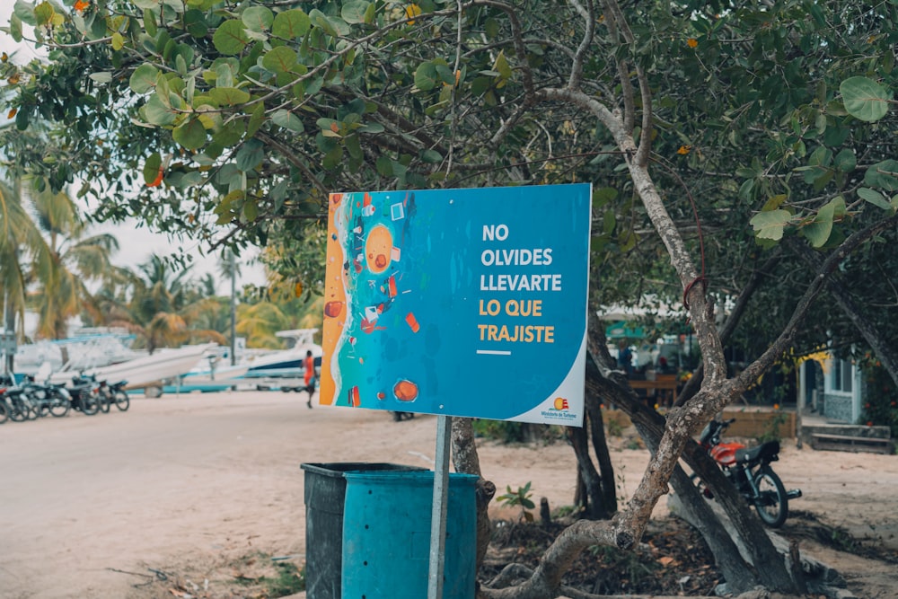 a blue sign sitting on the side of a road