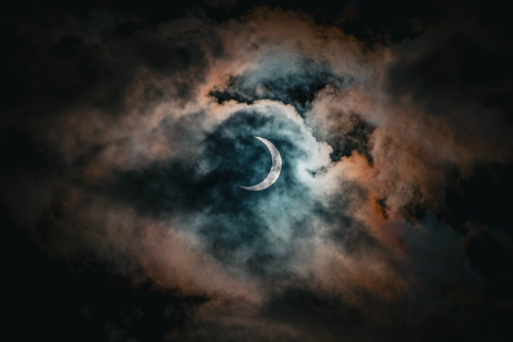 La luna è vista attraverso le nuvole nel cielo notturno