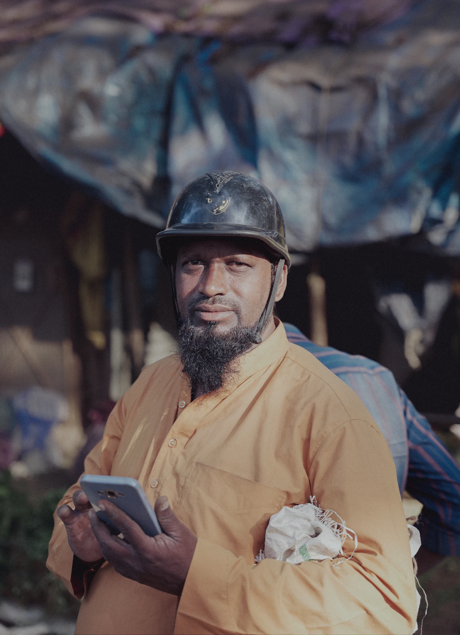 A worker in a helmet holding a tablet on site