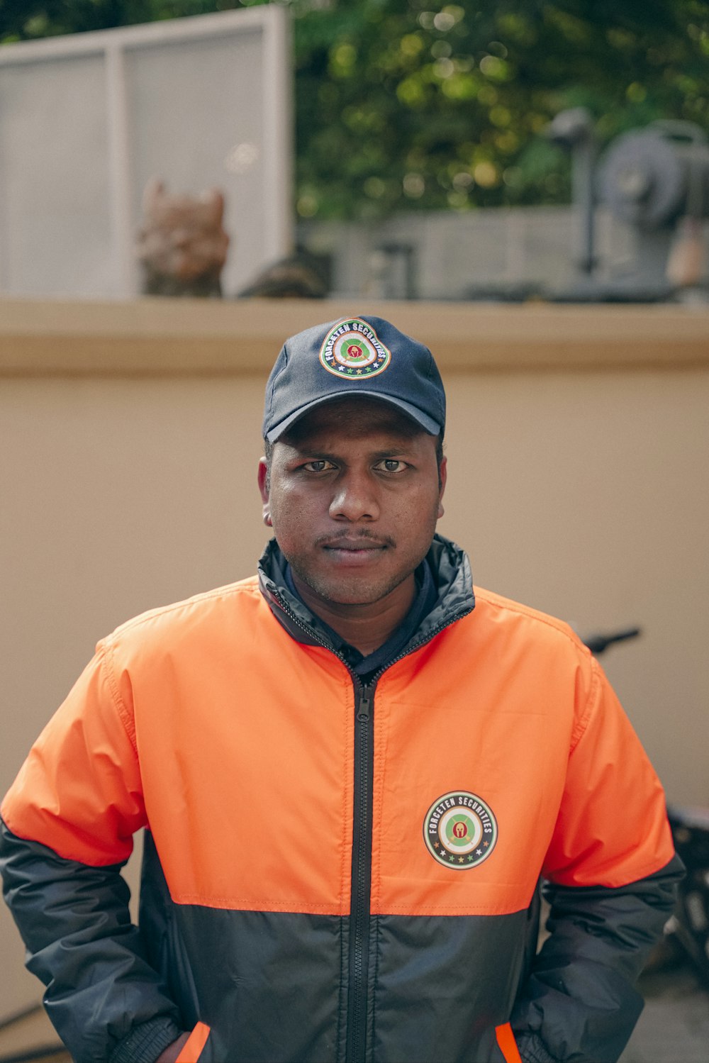 a man wearing an orange and black jacket and hat