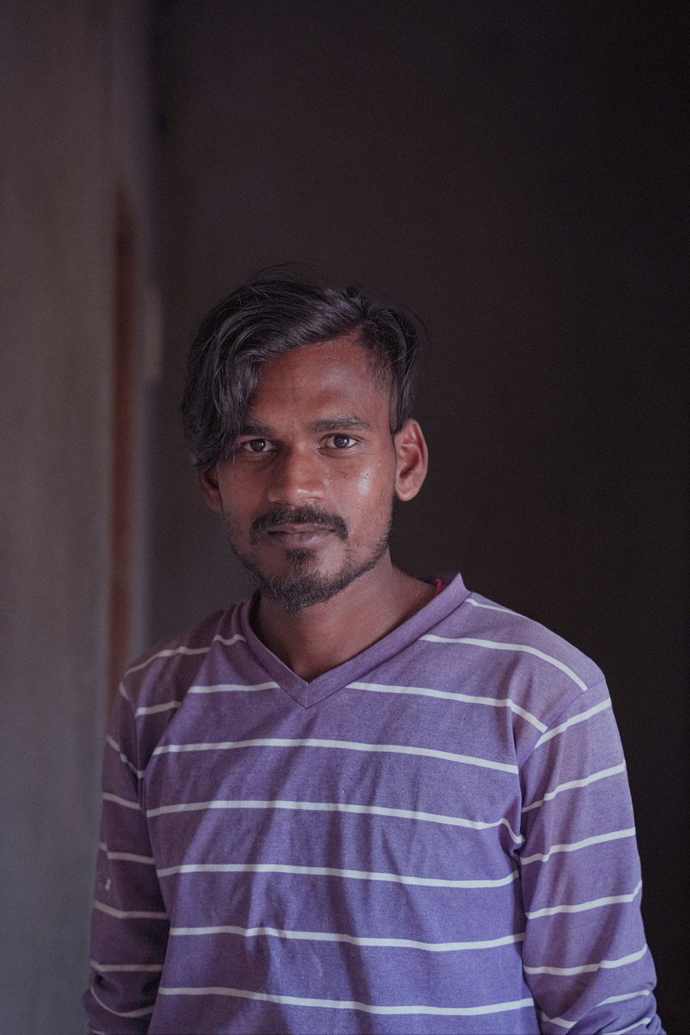 a man in a purple shirt standing in a room