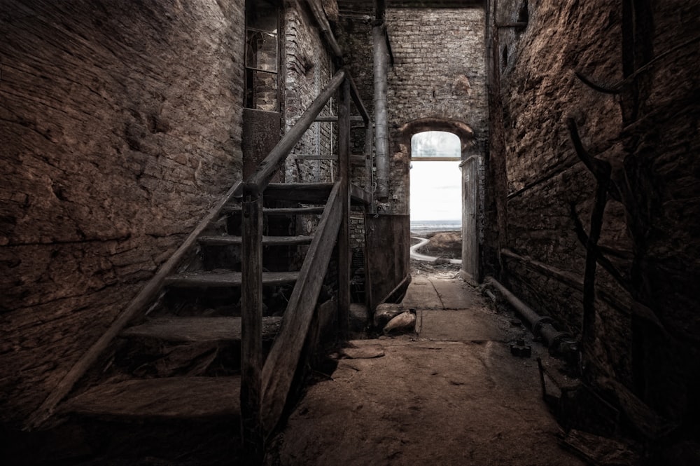 a dark hallway with a ladder leading to a window