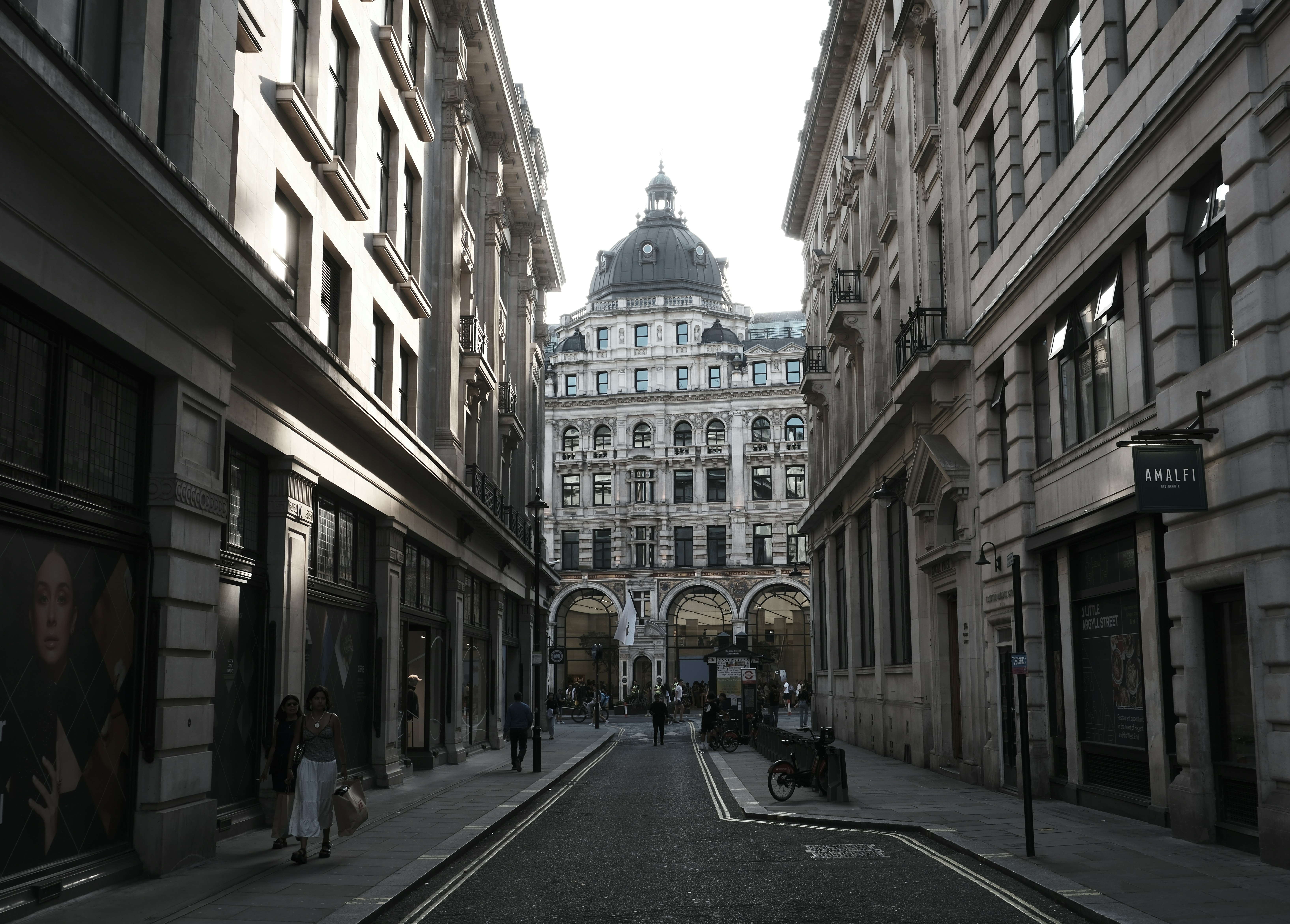 a narrow city street lined with tall buildings