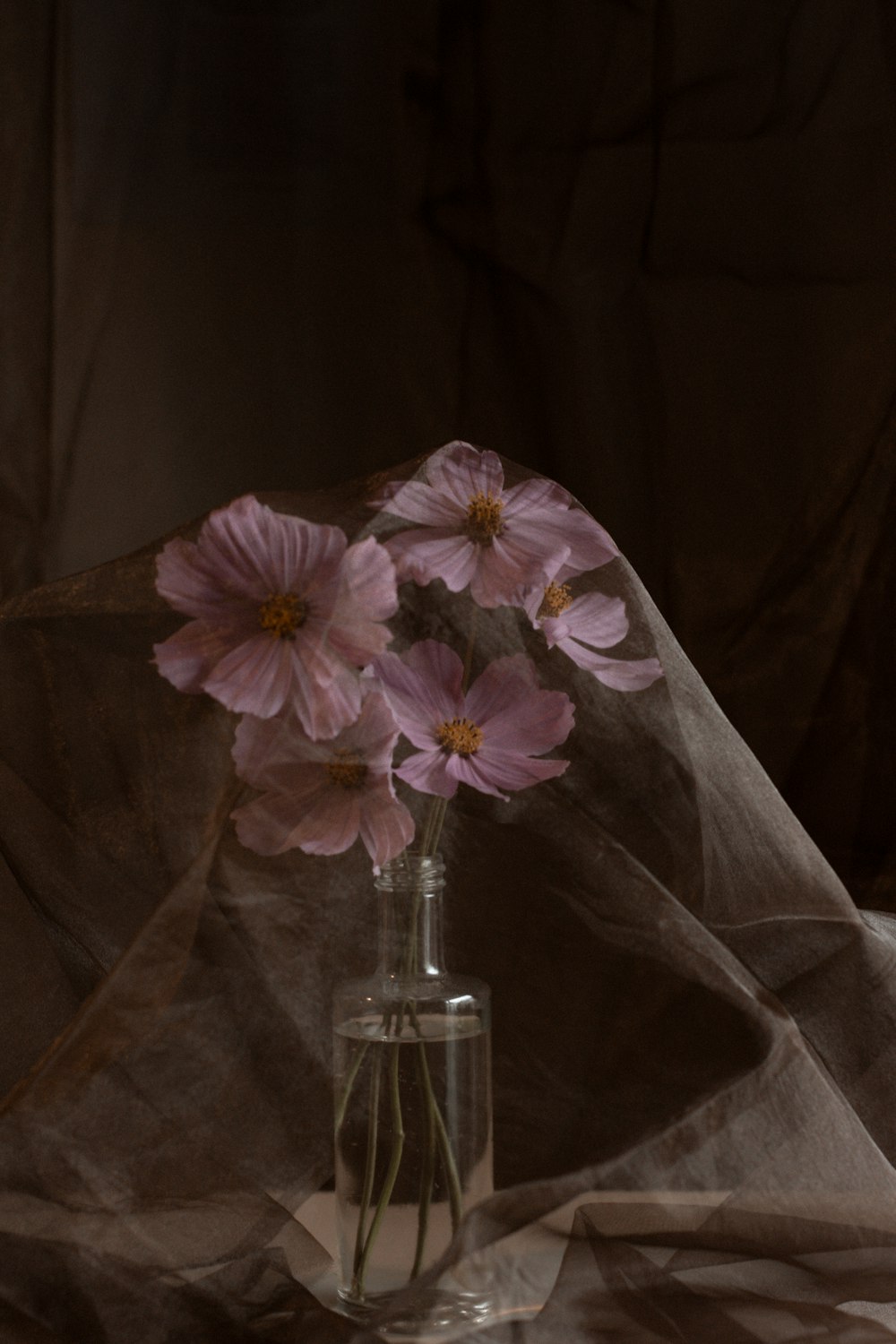 um vaso cheio de flores cor-de-rosa em cima de uma mesa