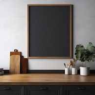 A minimalist kitchen counter with green leafy vegetables and herbs laid out neatly beside a recipe notebook.